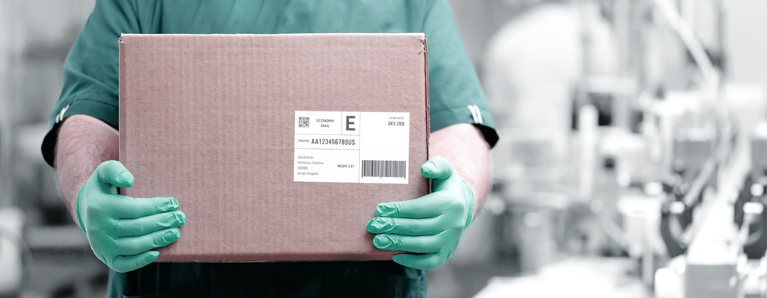 Verpakt product met etiket vastgehouden met groene handschoenen